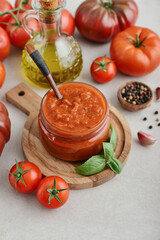 Traditional tomato sauce in a glass jar with fresh basil