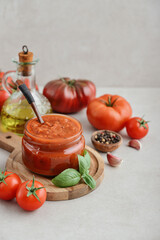 Traditional tomato sauce in a glass jar with fresh basil