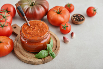 Traditional tomato sauce in a glass jar with fresh basil