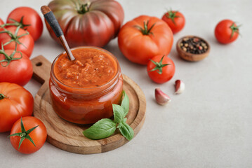 Traditional tomato sauce in a glass jar with fresh basil
