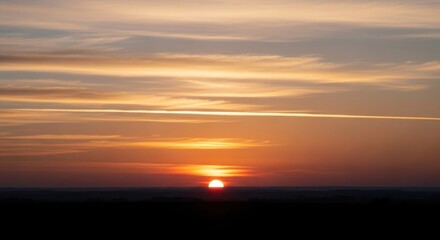 Serene sunset over horizon with vibrant sky and clouds