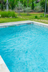 Obraz premium Empty swimming pool with sunbed and white umbrella in resort hotel for vacation leisure and white sand,resort neary sea and beach in summer.