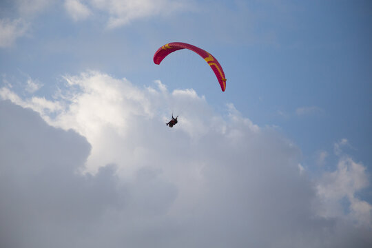 Persone su paracadute rosso per parapendio