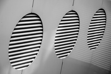 Modern Architectural Detail with Abstract Oval Vents in Black and White Casting Dynamic Shadows