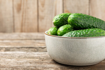 Cucumber on wooden background. Slice of cucumber on background. Fresh organic green cucumbers gherkin. Vegan. Salad ingredient. Farm vegetables. Cut vegetables with knife. Space for text. Copy space