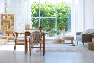 Beautiful table setting, chairs and decor in dining room. Interior design