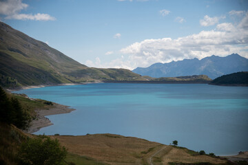 Scenic view of Plan des Fontainettes lake in the French Alps, with turquoise water, mountain backdrop, . Peaceful alpine landscape, summer nature scenery.