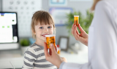 Child learns about medicine from caregiver in a bright clinic during a sunny afternoon