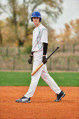 Engaging teenager confidently preparing for his turn at bat on the baseball field