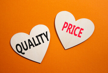 Price or Quality symbol. Concept word Price or Quality on wooden hearts. Beautiful orange background. Business and Price or Quality concept. Copy space