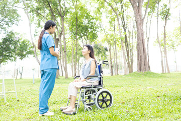 Fototapeta premium A friendly nurse assists an elderly woman in a wheelchair, providing care, support, and conversation during recovery in a retirement or healthcare setting.