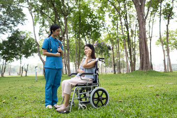 Fototapeta premium A friendly nurse assists an elderly woman in a wheelchair, providing care, support, and conversation during recovery in a retirement or healthcare setting.