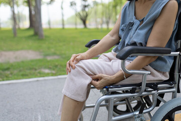 Obraz premium A smiling nurse assists a senior woman in a wheelchair outdoors, showing compassion, support, and togetherness in a caring healthcare environment. 