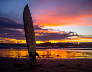 Surfboard Silhouette at Sunset on Sandy Beach