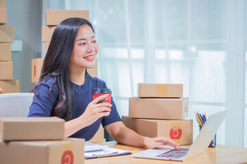 A smiling female entrepreneur manages inventory and shipping in a warehouse office, labeling...