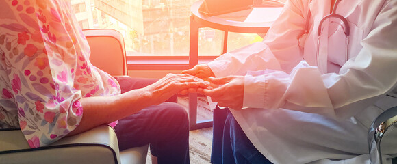 Geriatric doctor or geriatrician concept. Doctor physician hand on inpatient elderly senior patient to comfort in hospital examination room or hospice nursing home or wellbeing county.