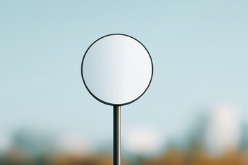 Blank round street sign mockup against clear blue sky and urban greenery