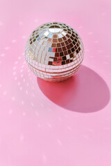 Disco Ball Reflecting Light on Pink Background