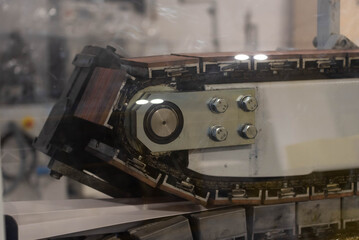Metal track behind plexiglass part of the process of fabricating plastic mold.