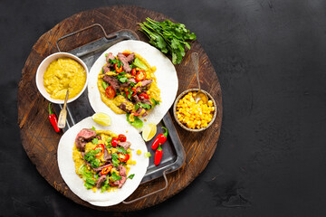 Mexican tacos, tortilla with beef, vegetable sauce, corn and tomatoes top view, copy space for text