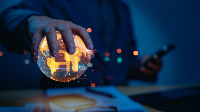 Businessman's hand holds glowing, holographic earth with bitcoin symbol. This represents global cryptocurrency, virtual financial technology, blockchain innovation, future investment, international