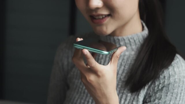 Asian woman using voice assistant AI learning on smartphone