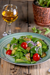 salad with greens, tomatoes and zucchini in a green plate