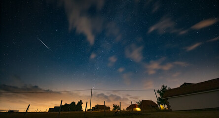 Milky Way stars and rural countryside silhouettes.