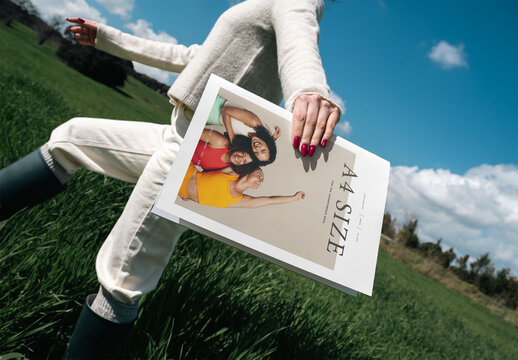 Mockup Of Woman Holding Customized A4 Magazine In Field