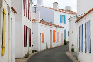 Typical street of french atlantic islands with white houses and colorful shutters