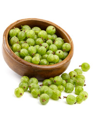 Fresh green gooseberries in a wooden bowl, surrounded by scattered berries, showcasing vibrant colors and natural textures, perfect for culinary uses and healthy recipes