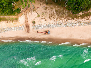 Aerial view of excavator and construction work on the beach.