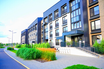 Ornamental grass in landscape design. Planting ornamental grass, shrubs in city infrastructure. Landscape Design for yard of Apartment buildings. Landscaping for urban space. Facade Condo house block.