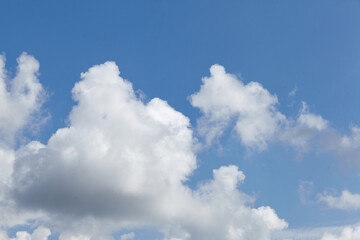 Bright blue sky filled with fluffy white clouds, creating a serene atmosphere, perfect for backgrounds or nature-themed designs with ample copy space for text