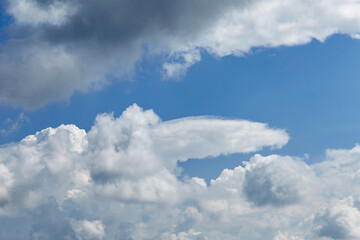 Expansive blue sky filled with fluffy white clouds, showcasing a serene atmosphere and dynamic cloud formations, perfect for backgrounds or nature-themed projects
