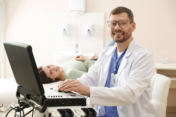 Sonographer with ultrasound machine and woman waiting for examination in clinic, selective focus