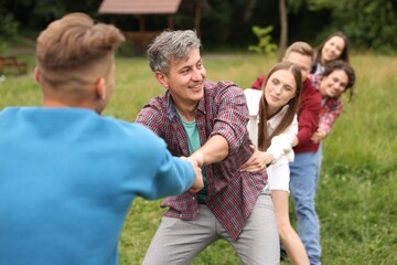 Fototapeta premium Team building. Group of happy people holding hands outdoors