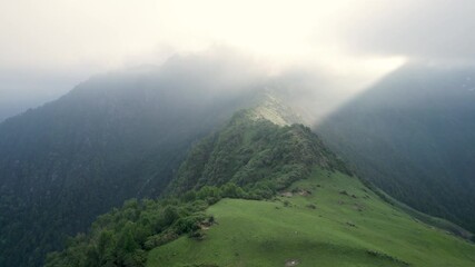 Drone shot of steep rocky slopes in the Garhwal Himalayas at sunrise, with the mountains bathed in warm colors, Rudraprayag district, Uttarakhand, India.