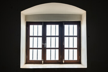 Old brown window frame in a vintage house. Threefold wooden window.