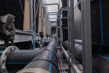 Cooling towers in data center building. Air conditioning cooling towers in front of building with fins to the front. Industrial cooling towers or air cooled water chillers with piping system.