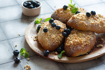 Buns with berry filling, blueberries and mint on a gray background. Polish dessert Jagodzianki 