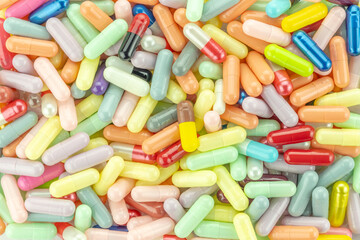 Colorful medicine pills and capsules background. A vibrant texture or pattern from a top-down view for the pharmaceutical industry.