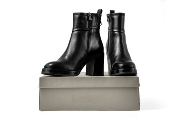 Female elegant high heeled leather ankle boots on its box. Isolated on a white background with clipping path included