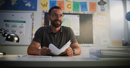 Male Teacher Presenting School Test Results to Elementary School Student, Praising Young Boy for High Grades and Academic Success. Meeting to Support Child's Learning and Development. Dolly Shot.
