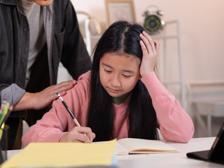 A father comforts his anxious daughter while she is learning online via tablet.