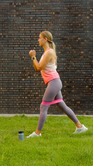 Woman exercising with resistance band on green lawn