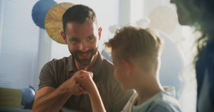 Mother and Father Looking at School Test Results of Their Son During Parents Evening. Parents Happy About Excellent Academic Performance and Behavior of Elementary School Boy. Slow Motion. Close Up.