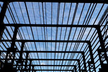 photograph looking up through the silhouetted structural framework of a large building.