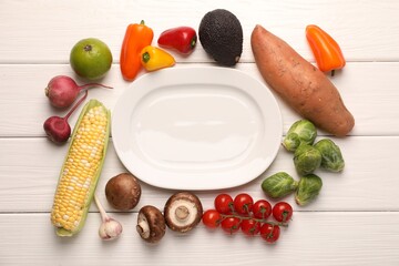 Healthy vegetarian food. Empty plate surrounded by different products on white wooden table, flat lay