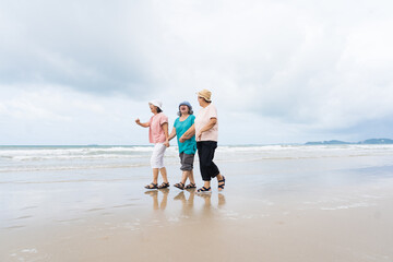 Tropical sand, sea, cloud and blue sky. Happy Asian senior women travel on beautiful sandy tropical beaches. Group of Asian elderly women walking and relaxing on tropical beach and sea on holiday